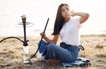 Narghileaua portabila experienta shisha oriunde te afli - femeie care fumeaza narghilea in natura